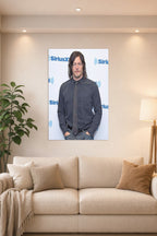Norman Reedus in a bright living room above a beige sofa.