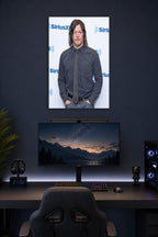 Norman Reedus in a gaming desk setup above a monitor.