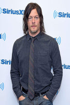 Norman Reedus poster features a full-length portrait in a dark blue shirt and striped tie before a SiriusXM backdrop.