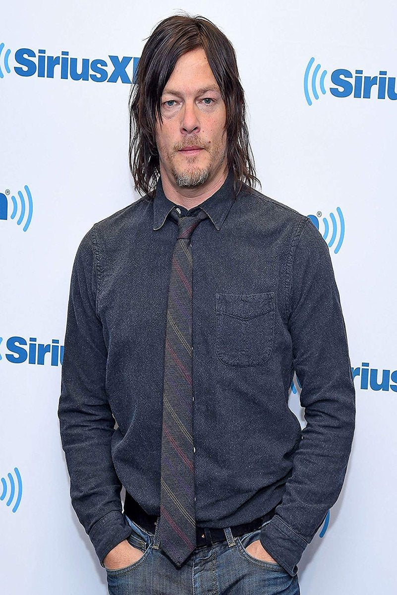Norman Reedus poster features a full-length portrait in a dark blue shirt and striped tie before a SiriusXM backdrop.