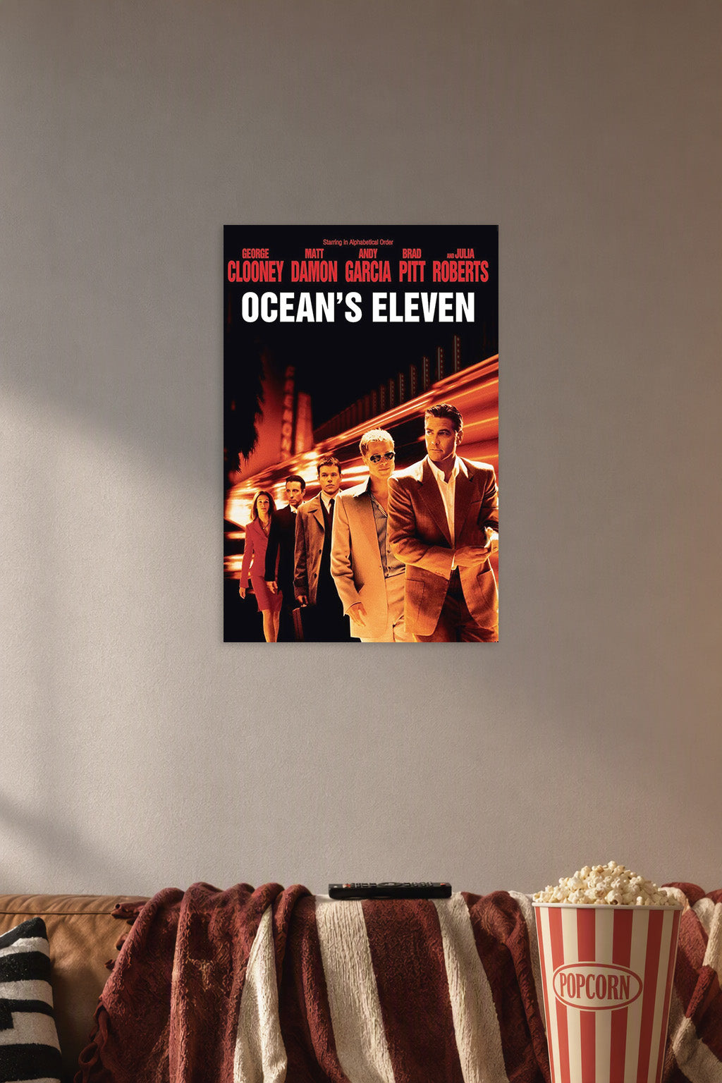 Ocean's Eleven Movie Poster in a cozy movie room above a brown sofa with popcorn.