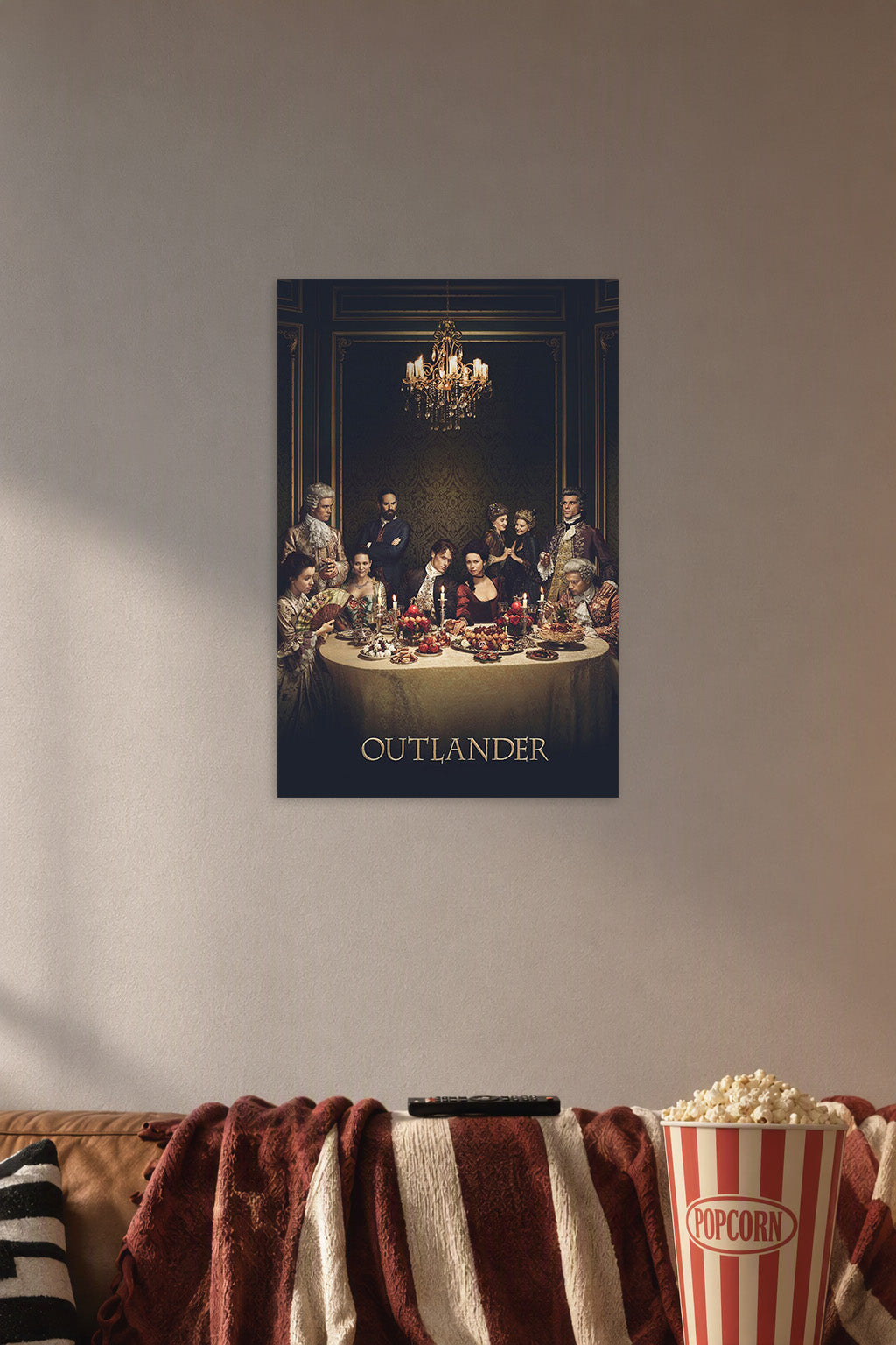 Outlander Cast Dinner Scene in a cozy movie room above a brown sofa with popcorn.