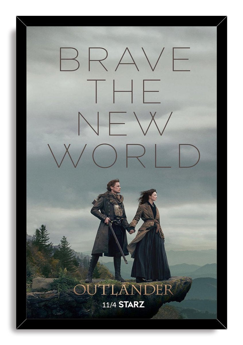Framed Outlander wall art print portrays Jamie and Claire holding hands on a rugged overlook beneath a gray, misty sky.
