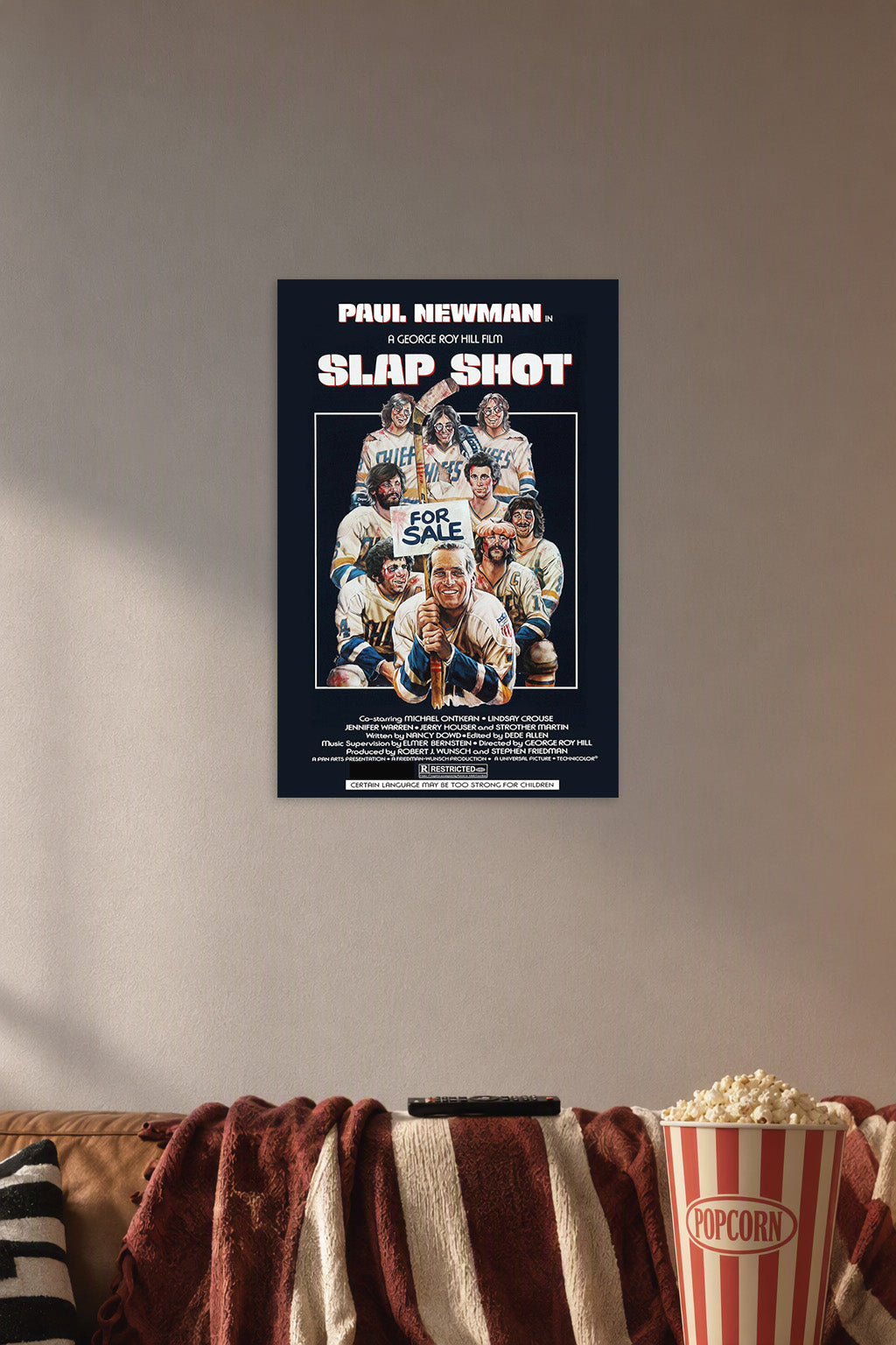 Paul Newman Slap Shot Movie in a cozy movie room above a brown sofa with popcorn.