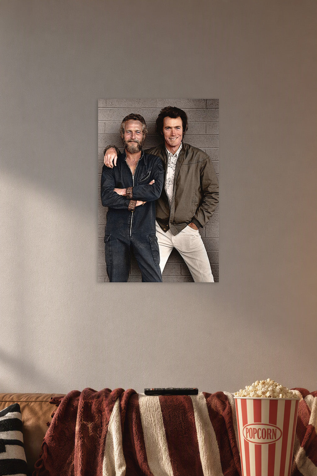 Paul Newman and Clint Eastwood in a cozy movie room above a brown sofa with popcorn.