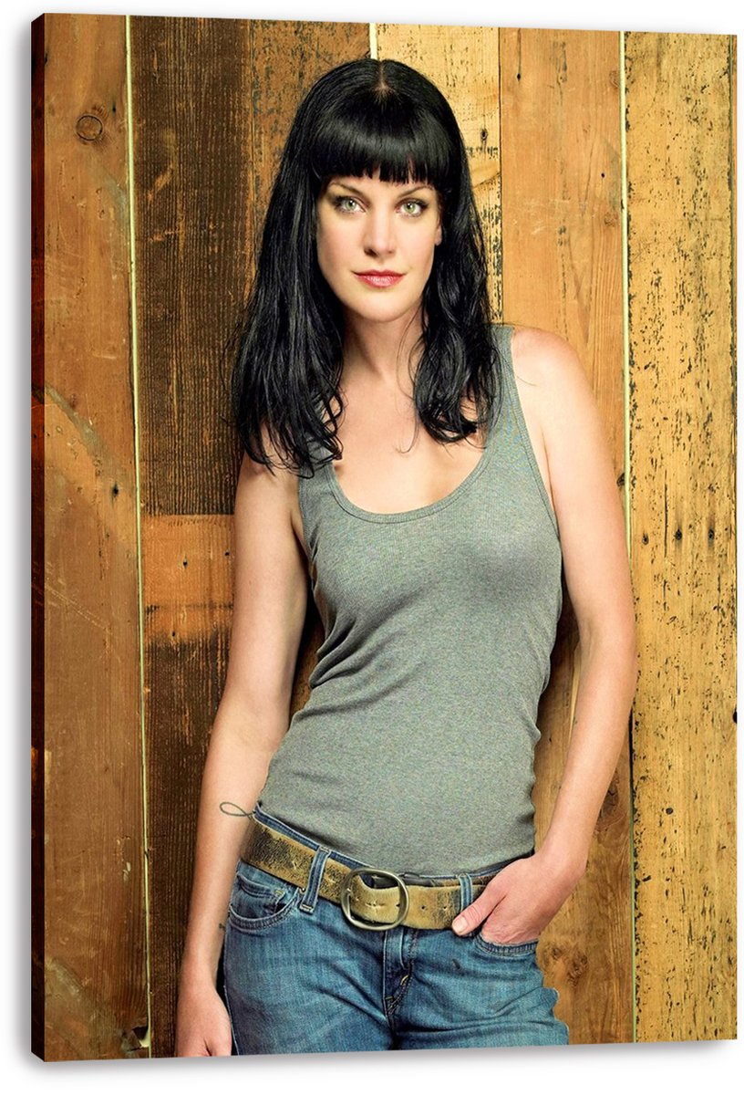 Pauley Perrette canvas wall art print featuring a woman in a gray tank top and blue jeans posed before weathered wood panels.
