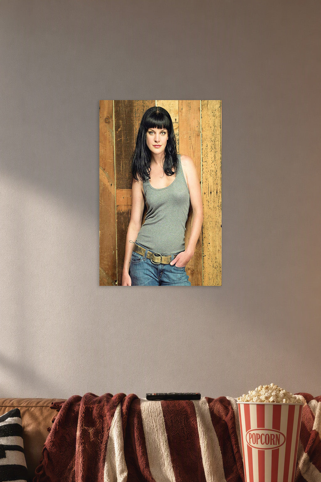 Pauley Perrette in a cozy movie room above a brown sofa with popcorn.
