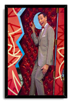Pee-wee Herman framed wall art print features him posing beside a red padded door, set in a black frame.