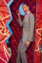 Pee-wee Herman poster depicts him in a gray suit and red bow tie beside a glossy red tufted doorway.