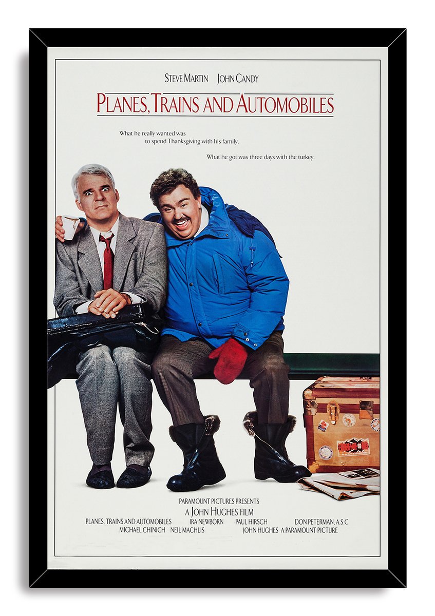 Planes, Trains and Automobiles framed wall art print with Steve Martin holding a cup beside John Candy in red mittens.