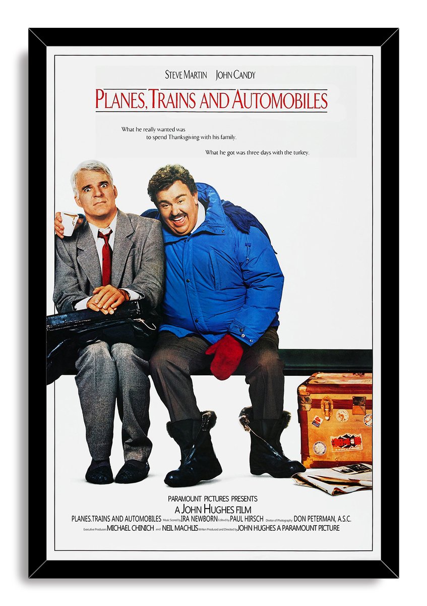 Planes, Trains and Automobiles framed wall art print featuring Steve Martin, John Candy, a black bag, and a suitcase.