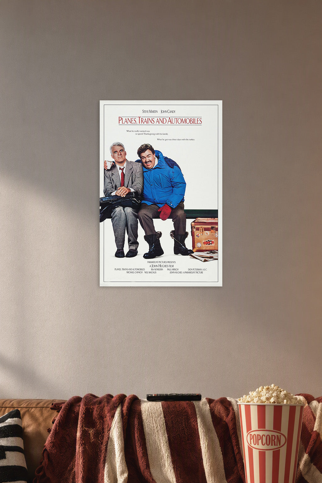 Planes, Trains & Automobiles Steve Martin John Candy in a cozy movie room above a brown sofa with popcorn.