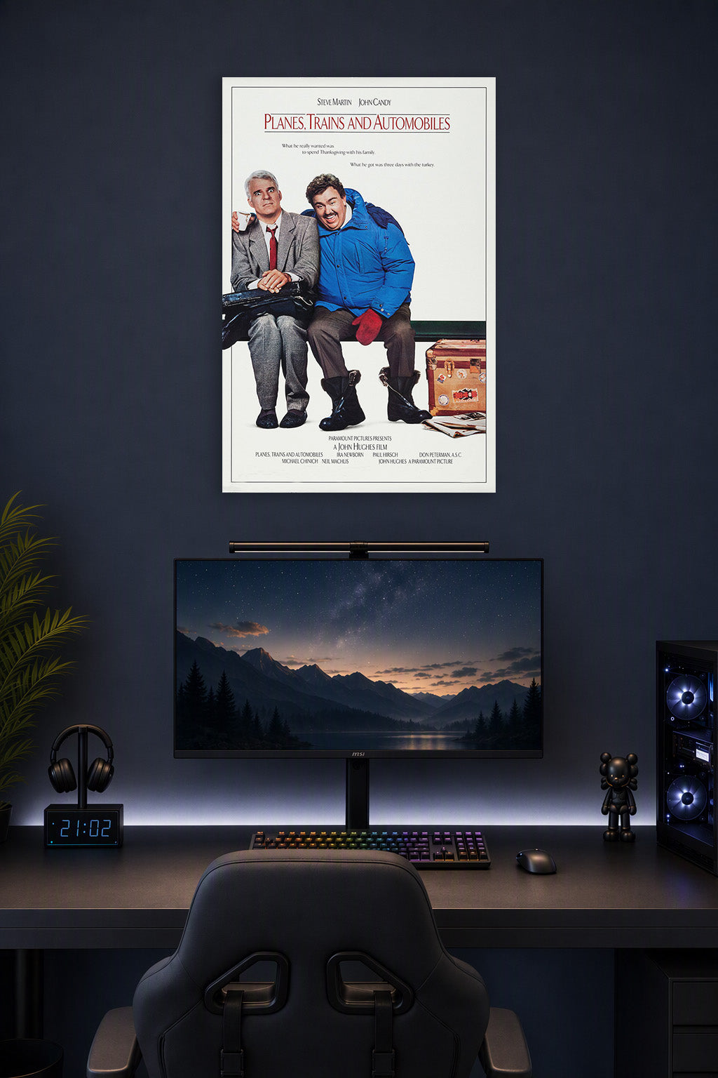 Planes, Trains & Automobiles Steve Martin John Candy in a gaming desk setup above a monitor.