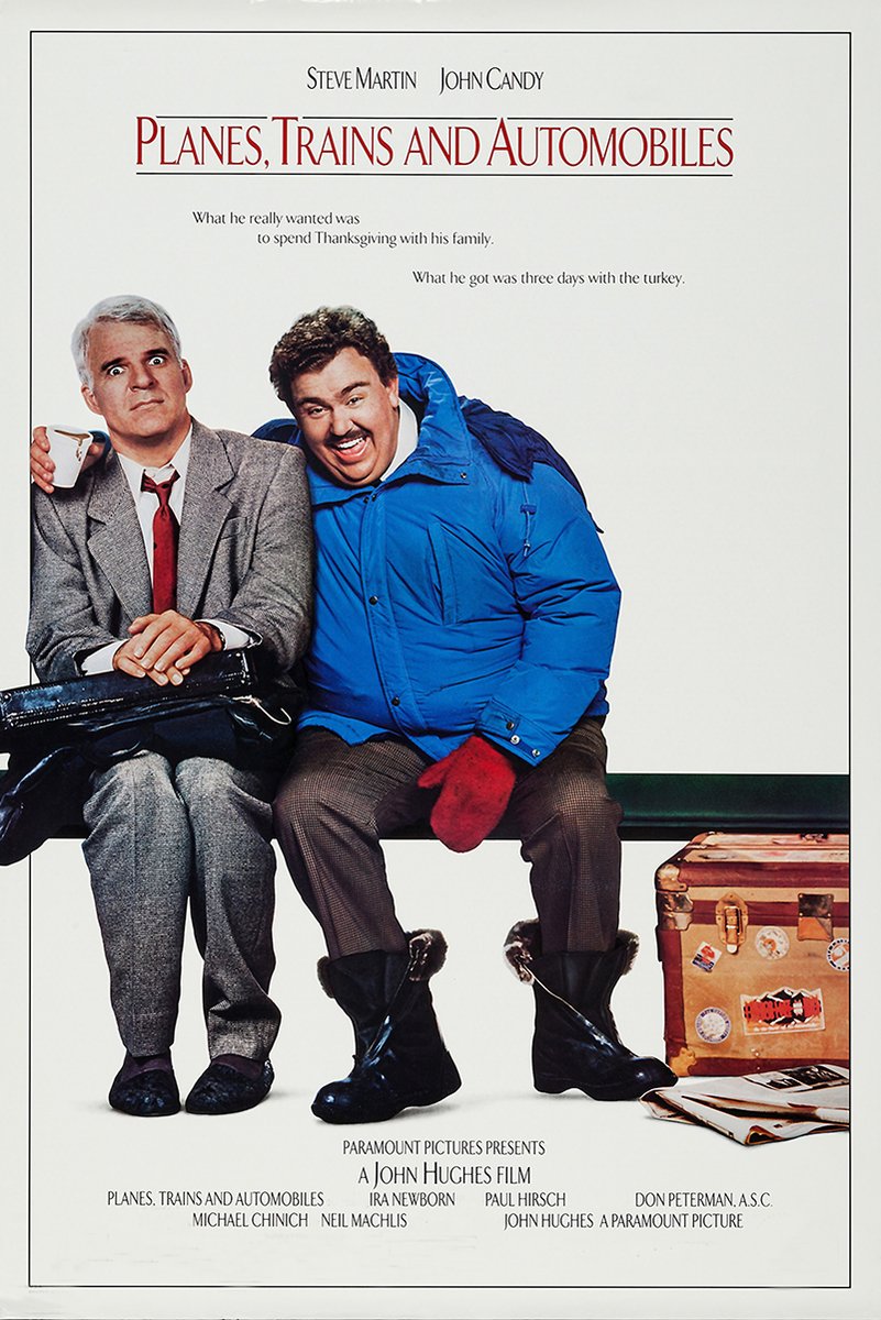 Planes, Trains and Automobiles poster with Steve Martin and John Candy seated beside a stickered suitcase and papers.