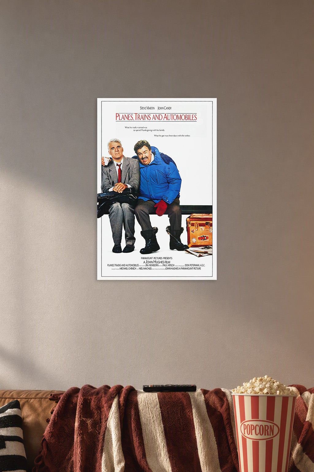 Planes, Trains & Automobiles Steve Martin John Candy in a cozy movie room above a brown sofa with popcorn.