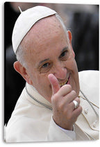 Pope Francis canvas wall art print displays the smiling pontiff in white robes and skullcap giving a thumbs-up against a dark background.