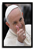 Pope Francis framed wall art print portrays the smiling pontiff in white papal attire giving a thumbs-up, set in a black frame.