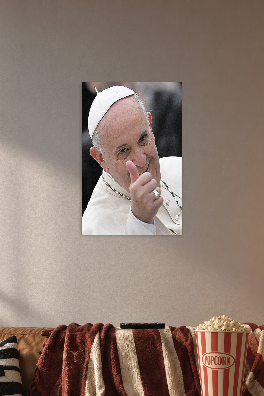 Pope Francis in a cozy movie room above a brown sofa with popcorn.