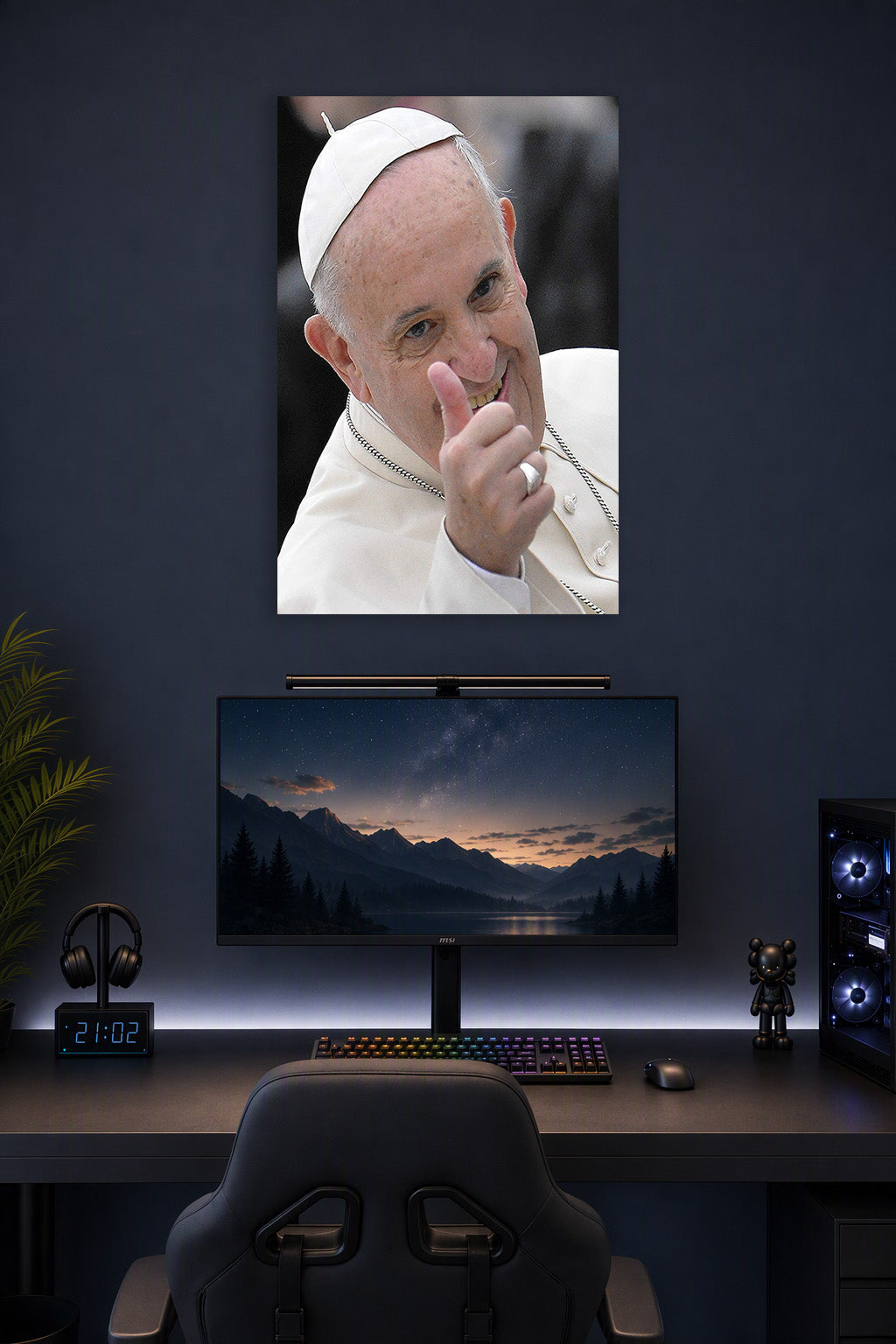 Pope Francis in a gaming desk setup above a monitor.