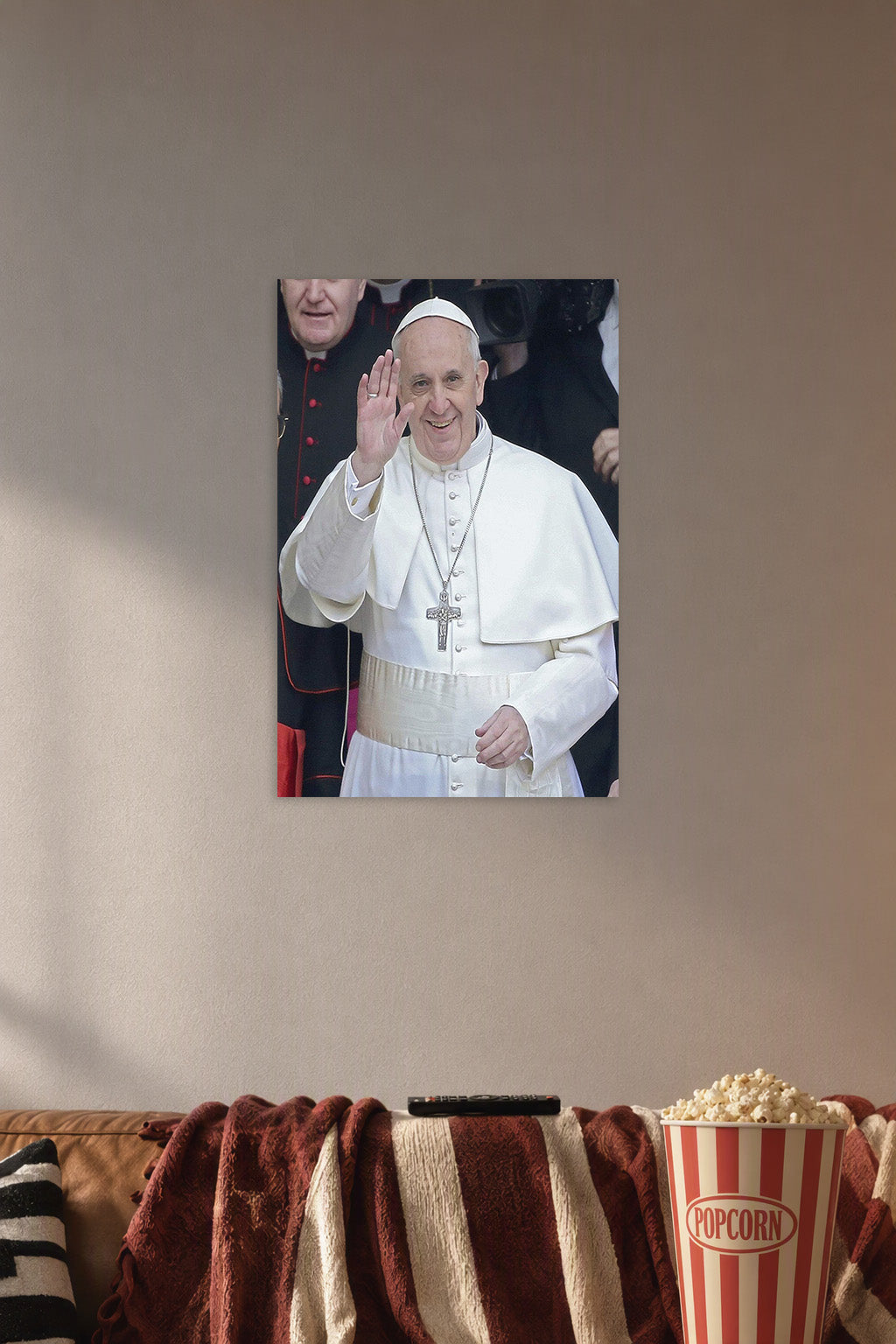 Pope Francis in a cozy movie room above a brown sofa with popcorn.