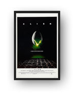 Alien movie wall art print presented in a black frame, featuring a luminous egg above a dark extraterrestrial ground.