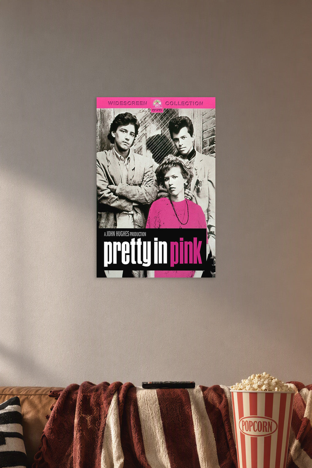 Pretty in Pink Movie Poster in a cozy movie room above a brown sofa with popcorn.