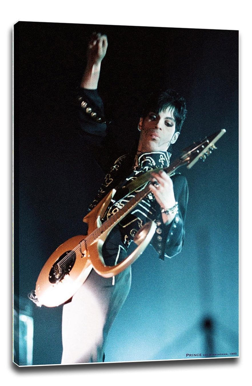 Prince canvas wall art print featuring the musician in a black embroidered jacket playing a gold guitar onstage.
