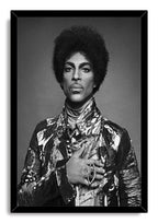 Prince framed wall art print displays a black-and-white portrait with an afro, ornate jacket, statement ring, and black frame.