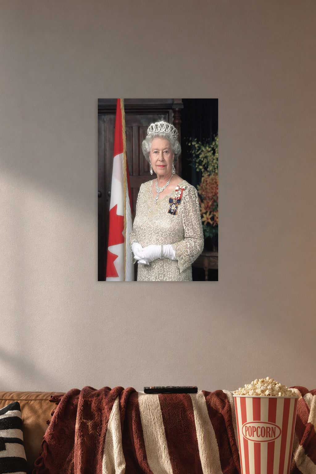 Queen Elizabeth II in a cozy movie room above a brown sofa with popcorn.