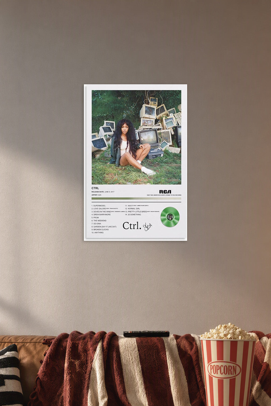 RCA Crtl Album Wall Art Poster in a cozy movie room above a brown sofa with popcorn.