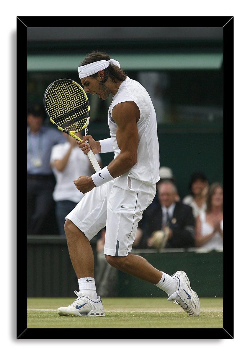 Rafael Nadal framed wall art print features the tennis player midair in white attire, framed in glossy black against a grass court.