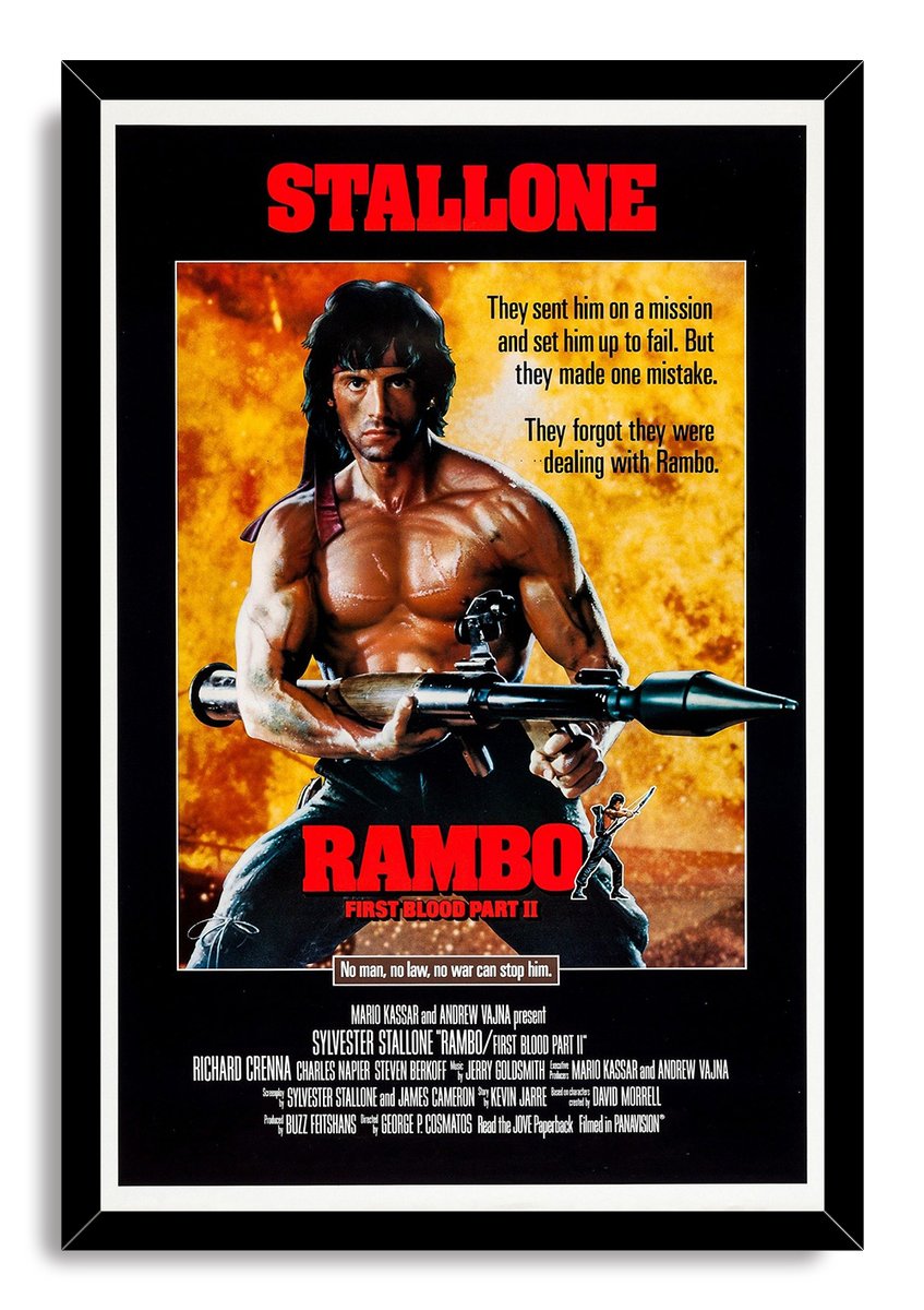 Rambo: First Blood Part II framed wall art print features Stallone gripping a rocket launcher before an orange explosion backdrop.