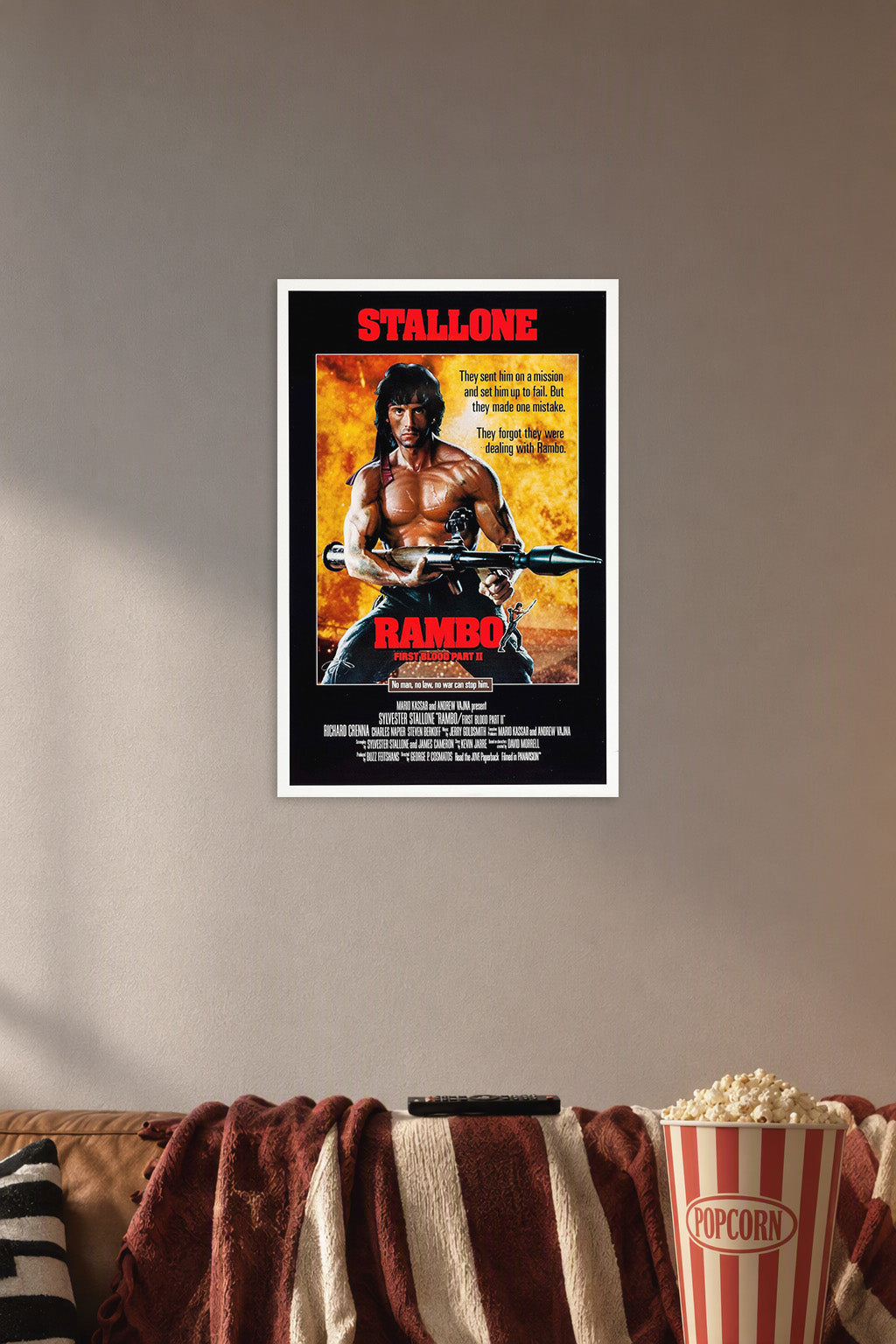 Rambo: First Blood Part II Sylvester Stallone in a cozy movie room above a brown sofa with popcorn.