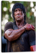 Rambo canvas wall art print featuring Sylvester Stallone bruised and bloodied in a dark shirt, displayed with visible wrapped edges.