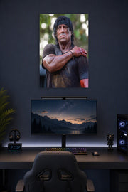 Rambo Sylvester Stallone in a gaming desk setup above a monitor.
