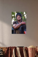 Rambo Sylvester Stallone in a cozy movie room above a brown sofa with popcorn.