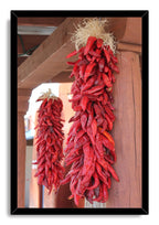 Red chili ristras framed wall art print featuring two hanging bunches of red dried peppers on a rustic wooden porch.