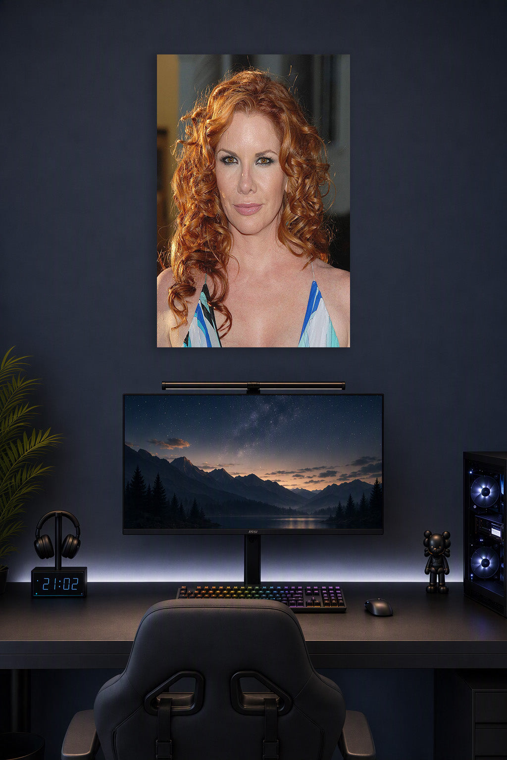 Redhead Celebrity in a gaming desk setup above a monitor.