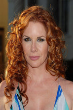 Redhead celebrity poster portrait with cascading copper curls, brown eyes, and a blue, white, and turquoise dress.