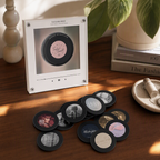 Retro mini vinyl record music player on a wooden table with Taylor Swift album-style discs scattered in front.