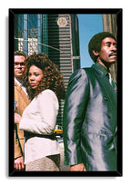 Framed wall art print of three fashionable people on an urban street, set against skyscrapers, blue sky, and a yellow taxi.