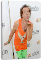 Richard Simmons canvas wall art print displays him blowing a kiss in a bright orange top before a white event backdrop.