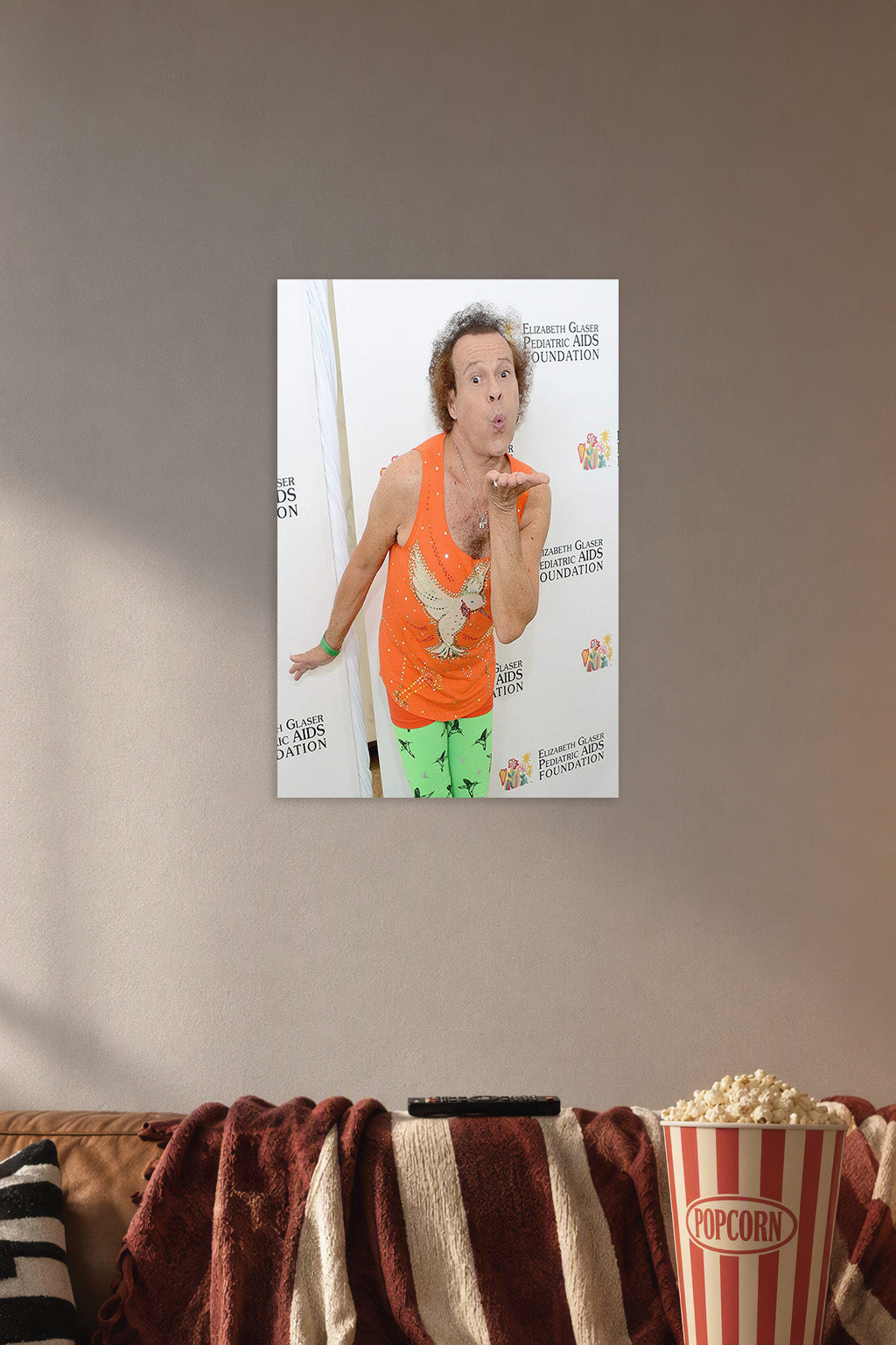 Richard Simmons in a cozy movie room above a brown sofa with popcorn.