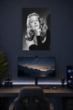 Rita Hayworth in a gaming desk setup above a monitor.
