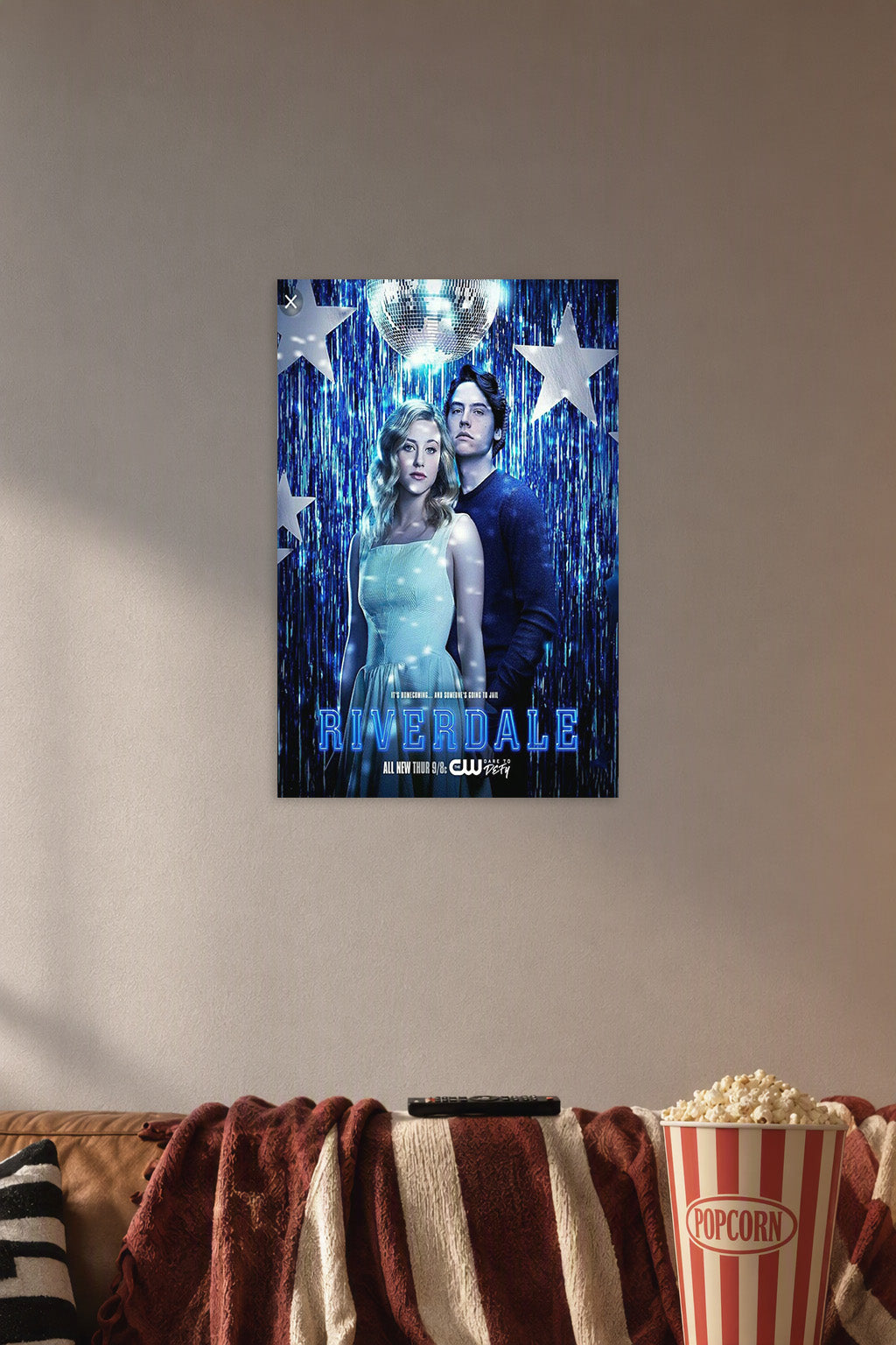 Riverdale Betty and Jughead in a cozy movie room above a brown sofa with popcorn.