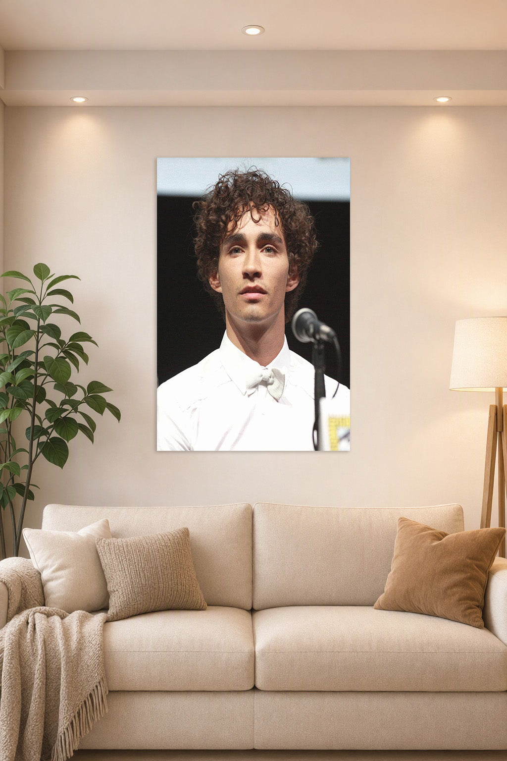 Robert Sheehan in a bright living room above a beige sofa.