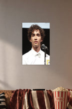 Robert Sheehan in a cozy movie room above a brown sofa with popcorn.
