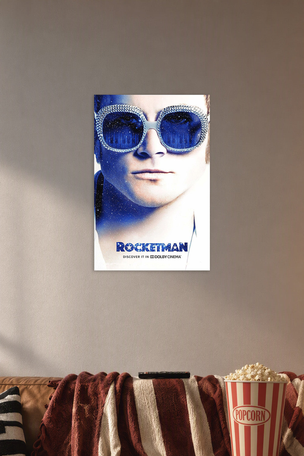 Rocketman Movie Elton John in a cozy movie room above a brown sofa with popcorn.