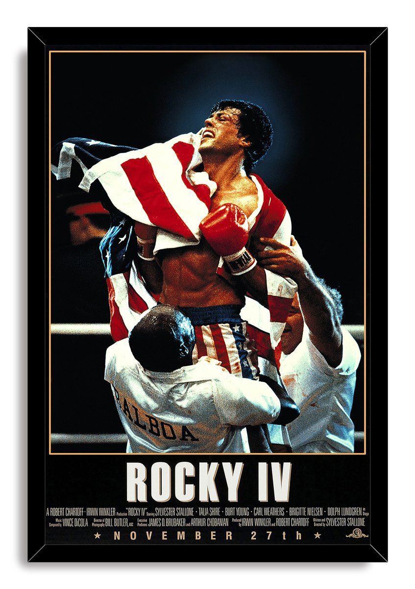 Rocky IV framed wall art print depicts Rocky Balboa wearing red gloves and flag-inspired trunks as trainers carry him.