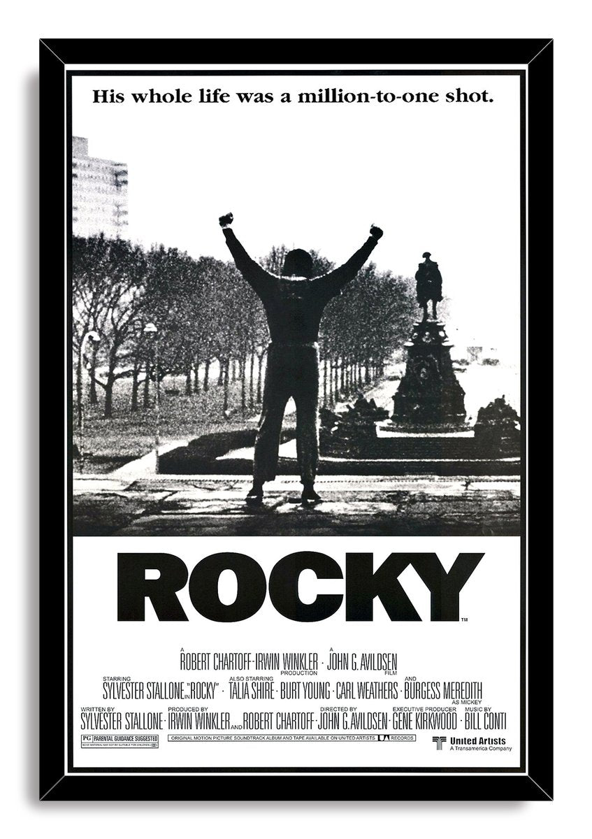 Rocky framed wall art print in a black frame, featuring a triumphant raised-fist silhouette, monument backdrop, and bold black ROCKY title.